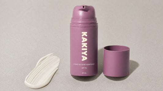 Flacon du fond de teint adaptatif Kakiya à côté d'un trait de produit blanc, kakiya avis